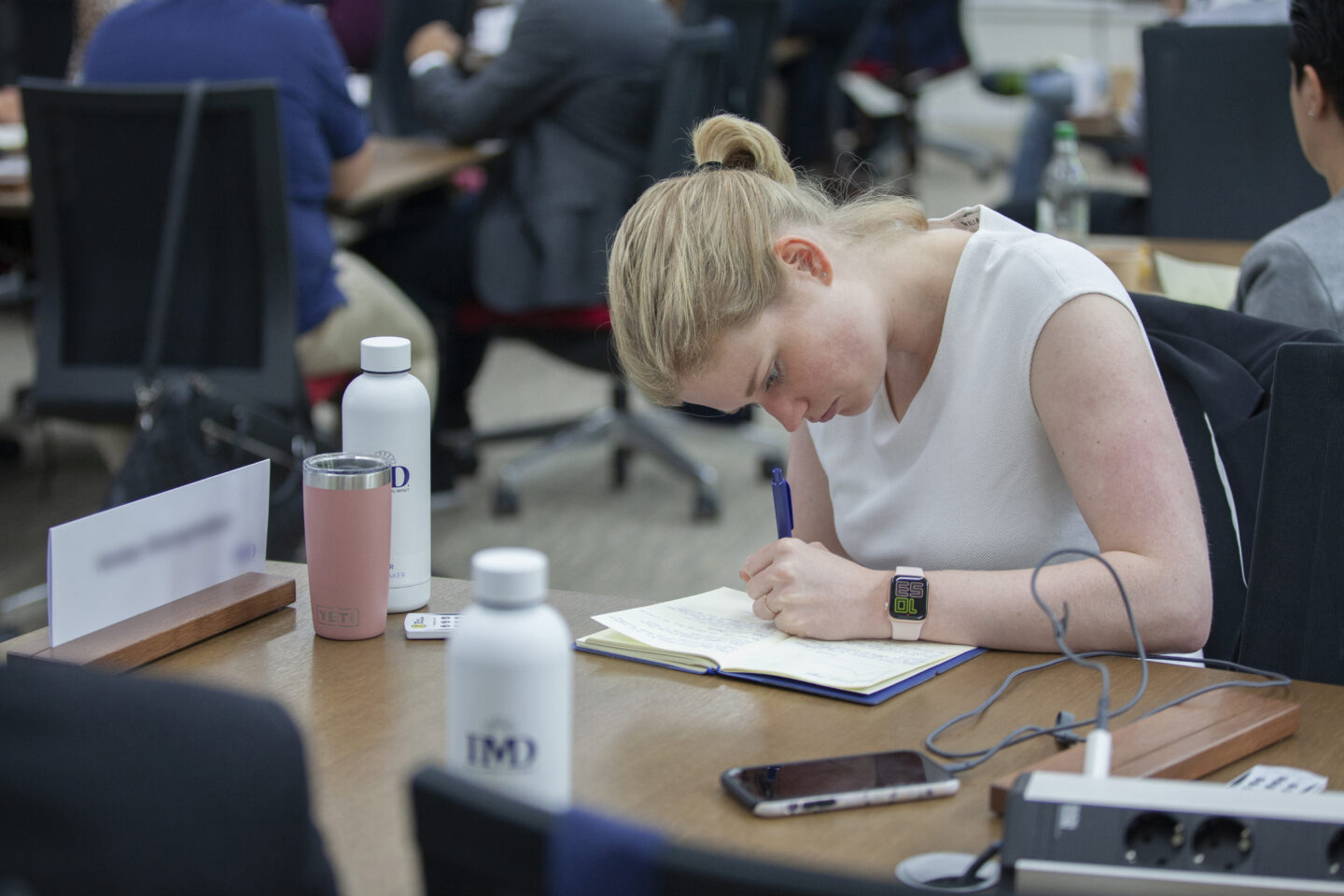 Participant taking notes at Didier Cossin’s speach at IMD OWP 2022, 1st July