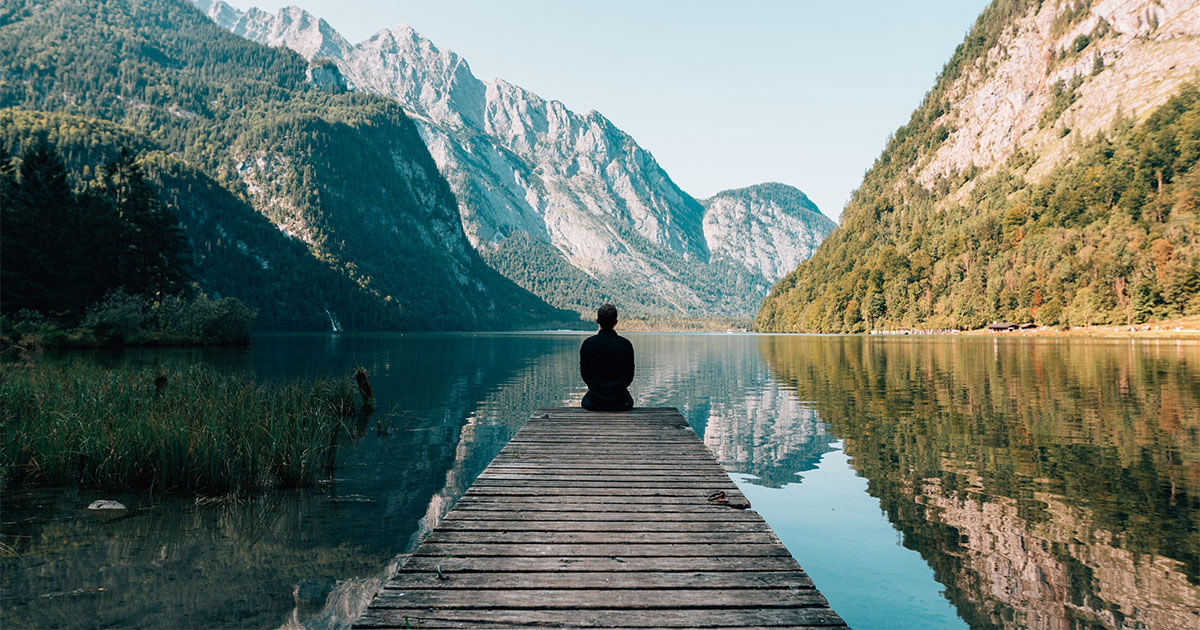 Future of healthcare - Man sitting on wood deck in front of a lake