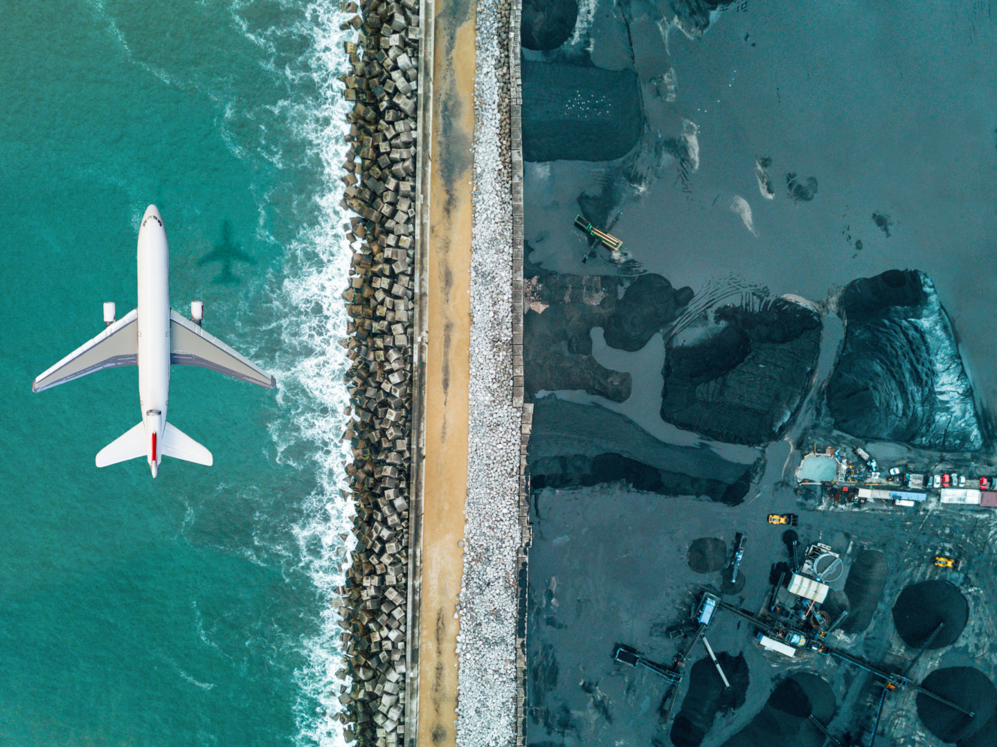 Airplane flying over a fossil fuels mine