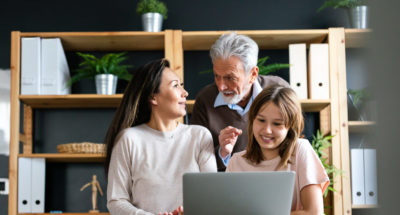 Happy multi generation multiethnic family spend time online with computer together at home, different generation over a aocmputer