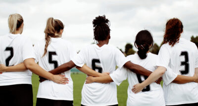 Female soccer players huddling and standing together Race team racial equity