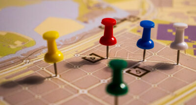 Closeup shot of colorful pins on the map supply chain reorganization - pawns moving on a map