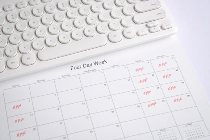 Calendar with four day work week, off days on Friday, Saturday and Sunday. Office desk with keyboard.
