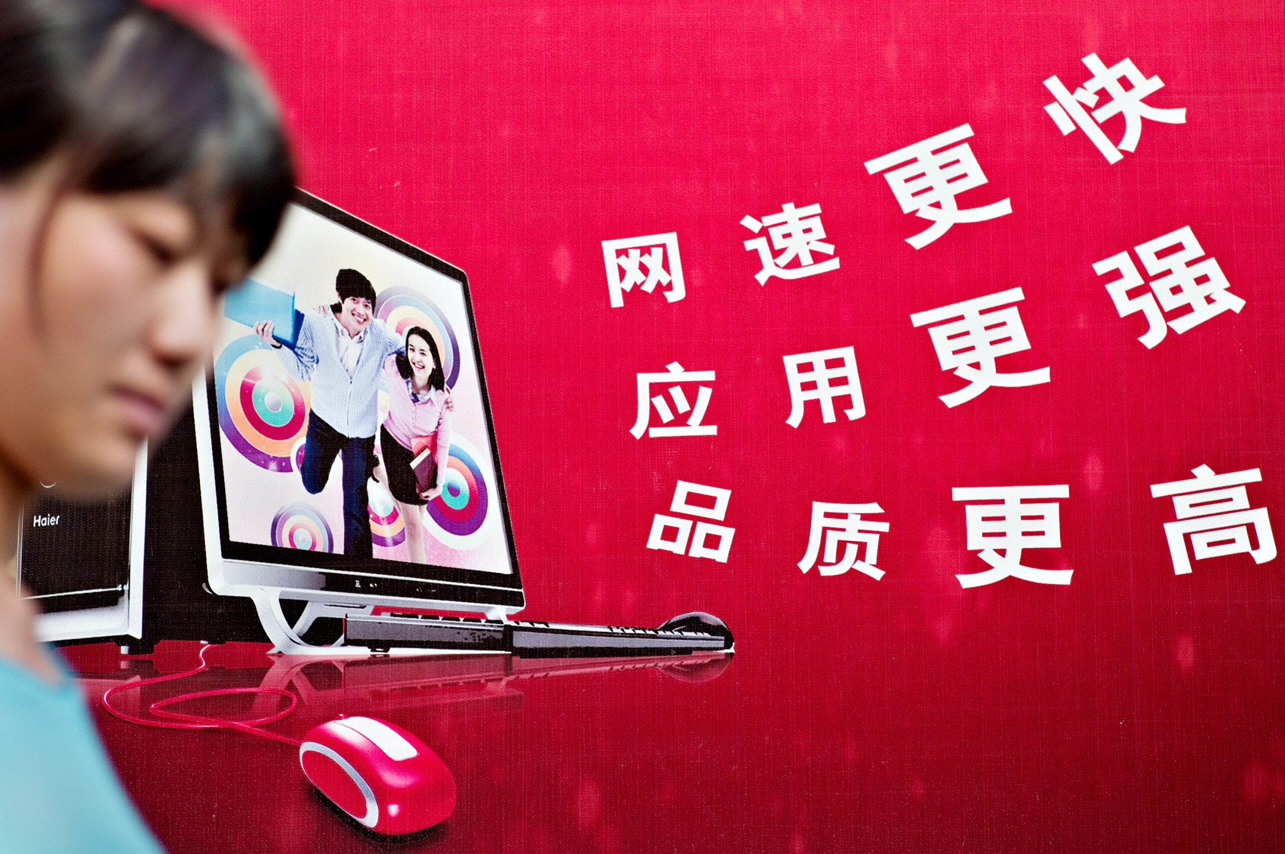 A woman walks past a chinese billboard advertising