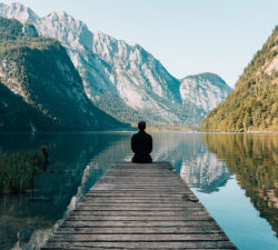 Future of healthcare - Man sitting on wood deck in front of a lake