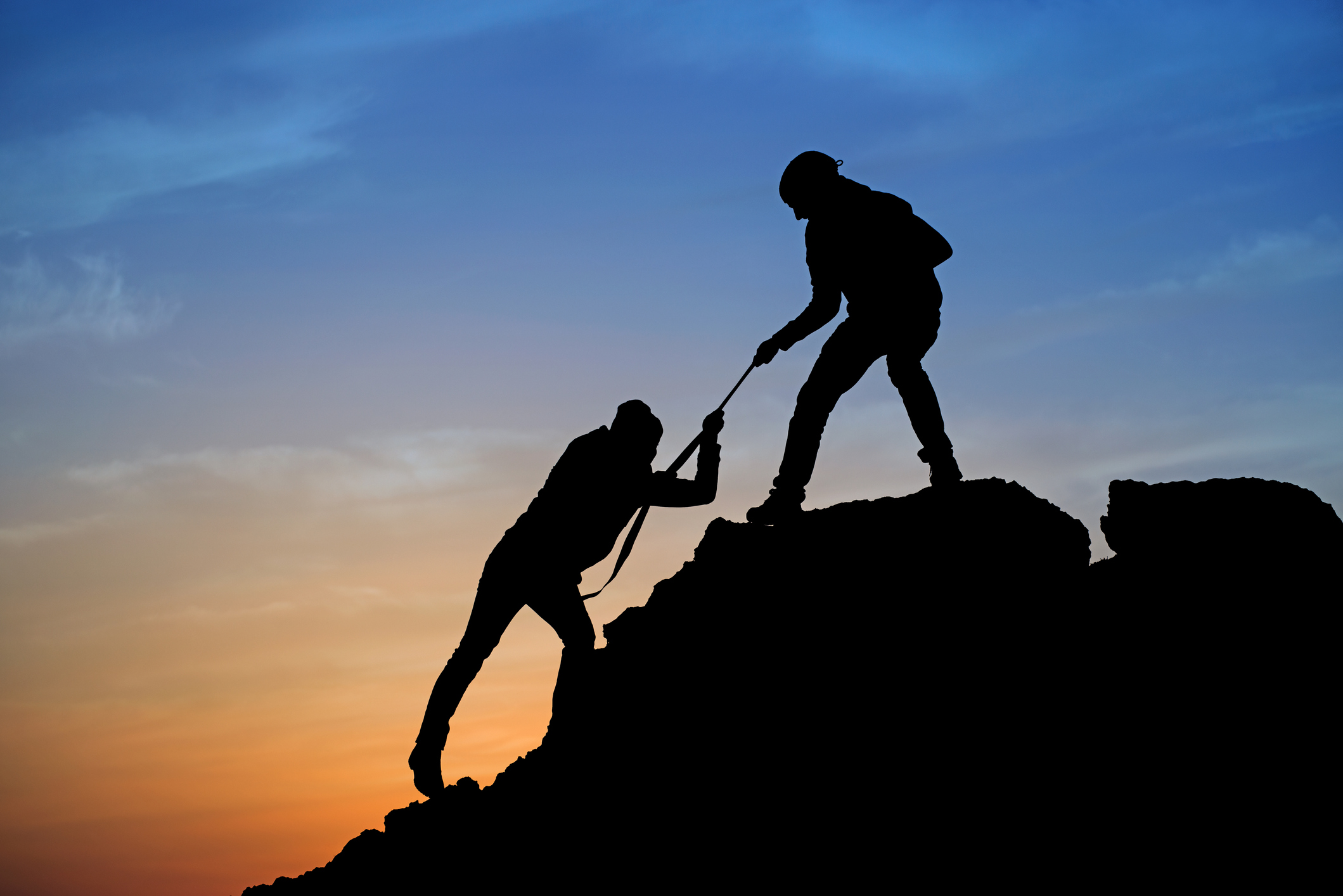 Silhouette of helping hand between two climber