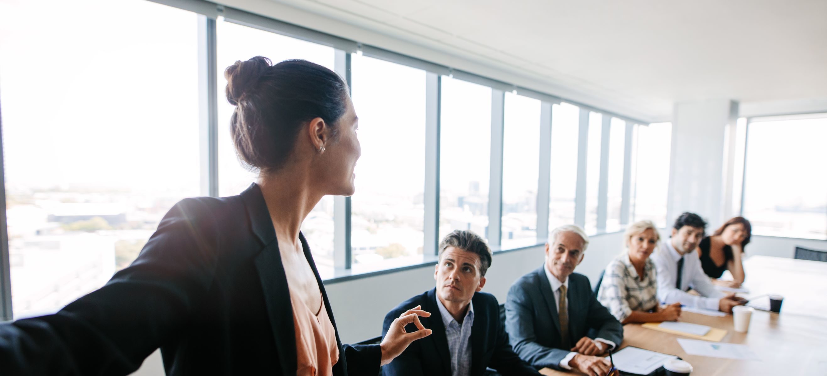 AdobeStock_151524961 Young woman talking in a board meeting