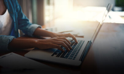 A woman typing on her computer - Stockphoto