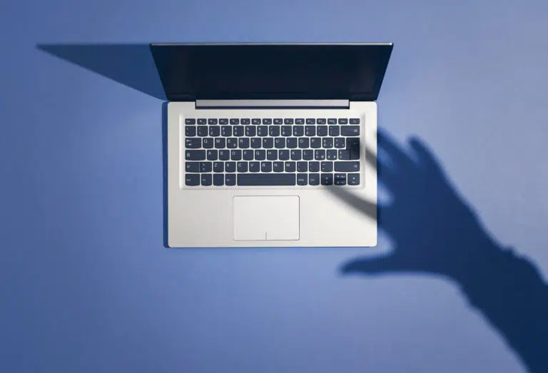 Threatening hand attacking a laptop and stealing information: cyber crime, hackers and malware concept - IMD Business School