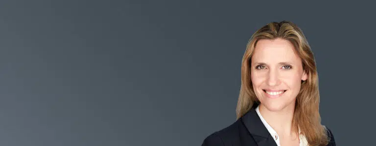 Portrait of Séverine Jourdain, IMD executive leadership and senior business coach, smiling in professional attire against a dark background. - IMD Business School
