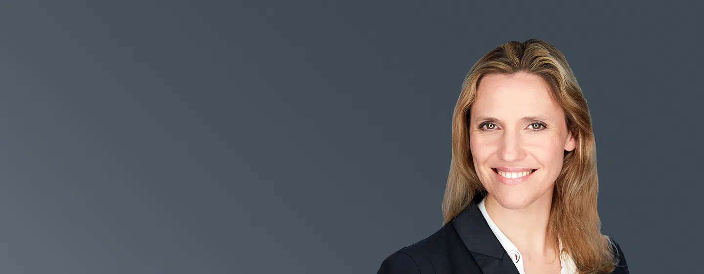 Portrait of Séverine Jourdain, IMD executive leadership and senior business coach, smiling in professional attire against a dark background. - IMD Business School