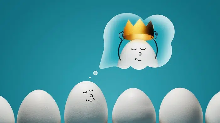 An egg is dreaming about golden crown on blue background. Concept of narcissism. - IMD Business School