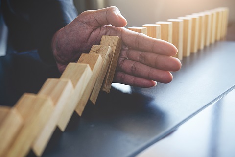 Hand stopping falling dominos - IMD Business School