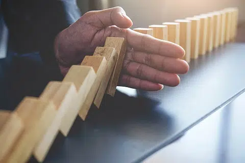 Hand stopping falling dominos - IMD Business School