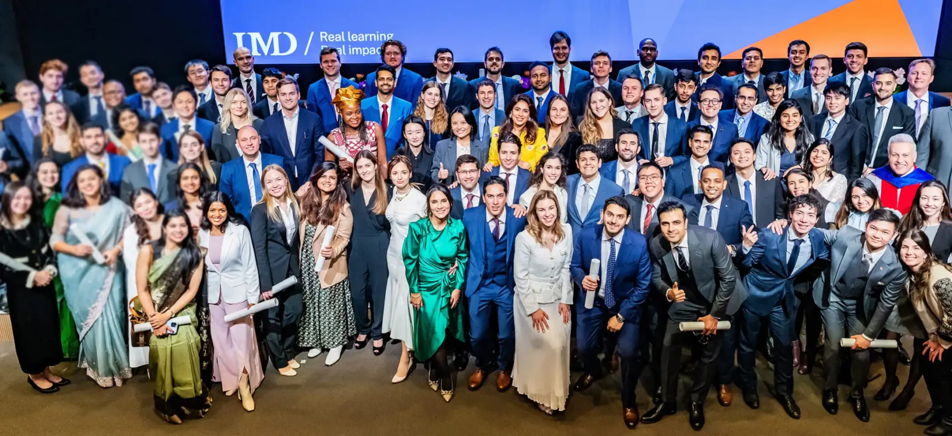 IMD MBAs graduating on stage and cheering - IMD Business School