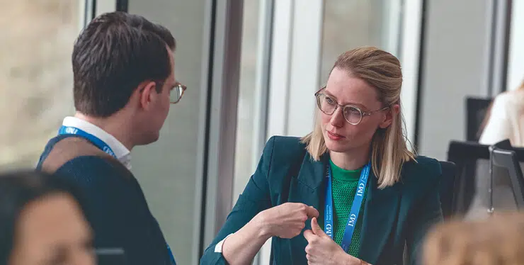 a man and a woman having a debrief following a talent assessment - IMD Business School