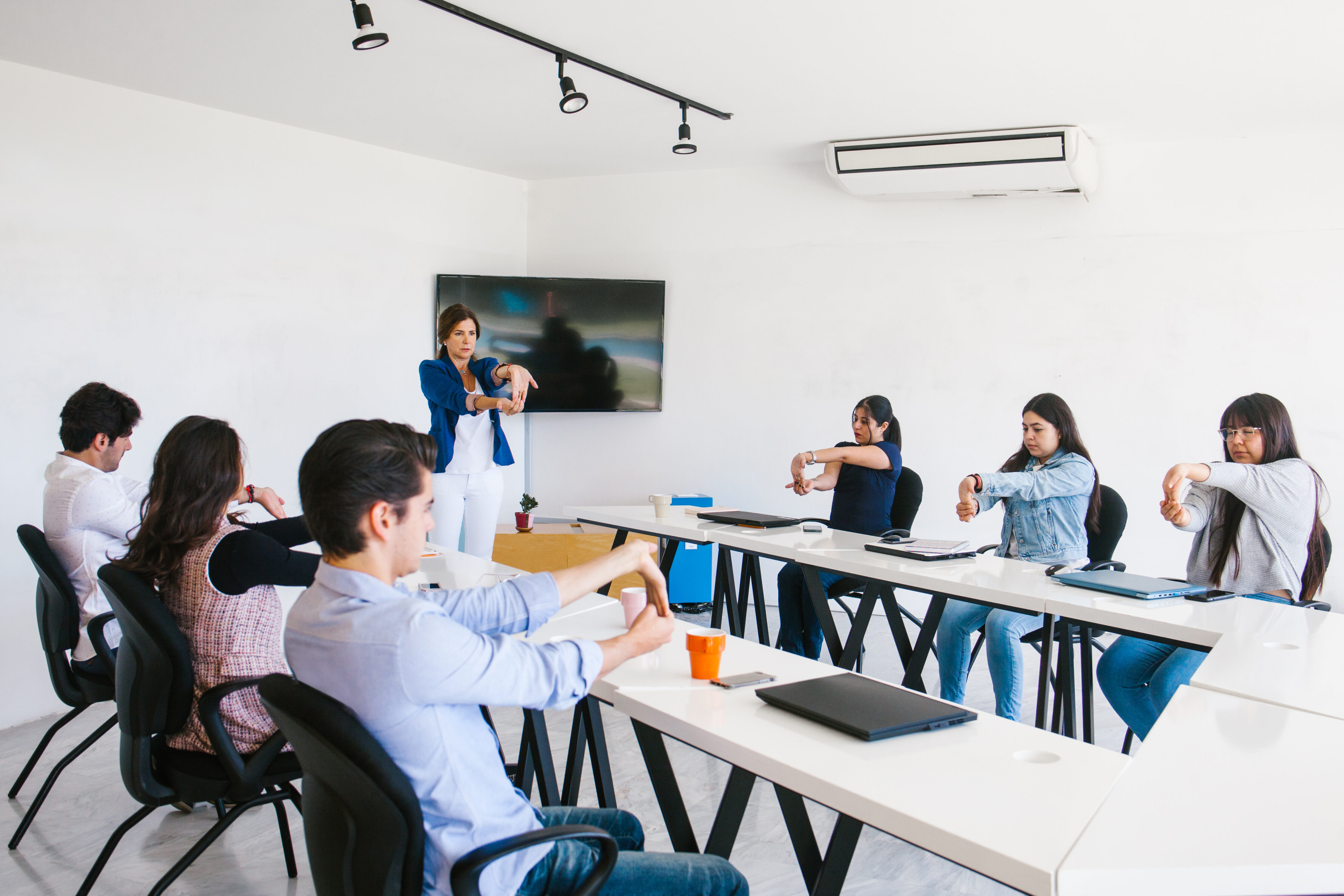 latin business people meditating and doing yoga in office in Mexico city
