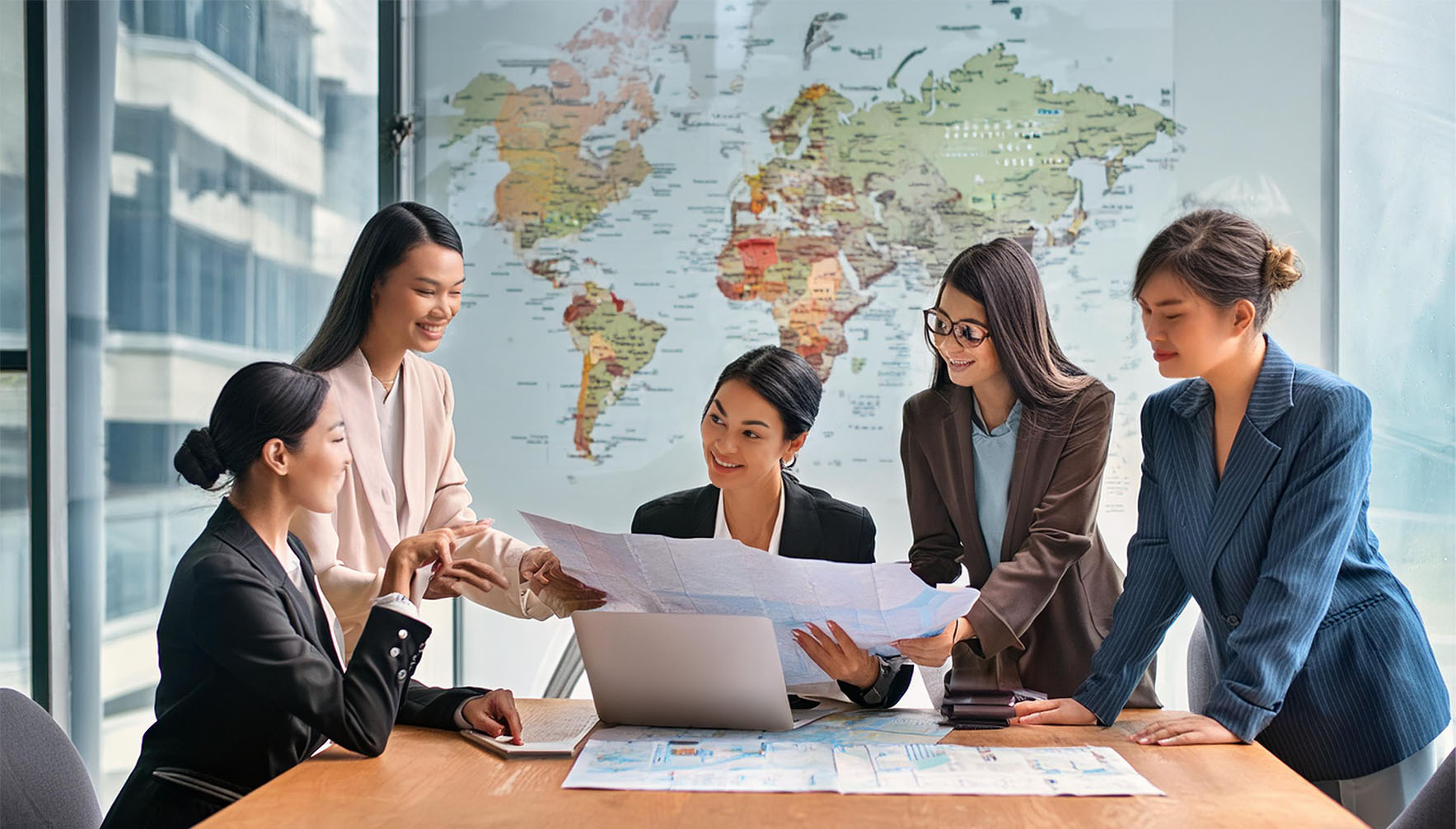 Diverse businesswomen discussing a project with map in front of them