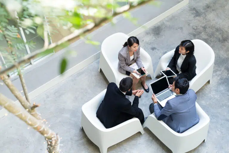 Top view of business people having discussion together - IMD Business School