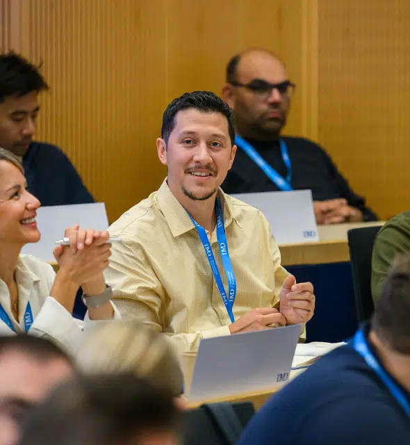 Attendees follow an IMD learning session from their seats in an auditorium. - IMD Business School
