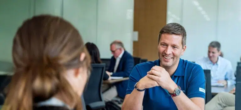 Group of business professionals in discussion during a sustainability-focused executive education program at IMD - IMD Business School