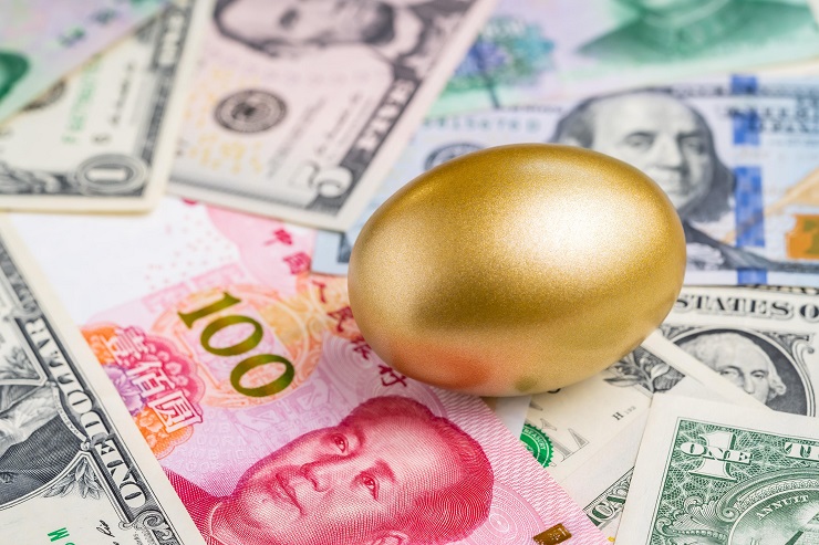 Gold egg sitting on top of some USS dollars and Chinese yuan - IMD Business School