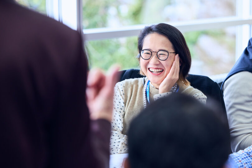 IMD EMBA Elective-flex participant during a classroom discussion - IMD Business School Smiling EMBA participant engaged in a leadership development session at IMD - IMD Business School