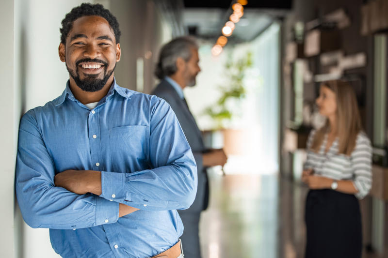 Portrait Of Businessman In Modern Open Plan Office With Business
