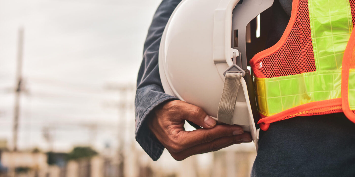Engineer holding white helmet safety hard hat copy spec