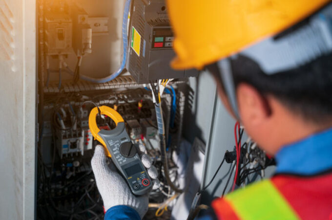 Electrician engineer tester measuring voltage and current of power electric line in electical cabinet controlElectrician use Digital Voltmeter Testing Voltage on automatic control boxSelective focus