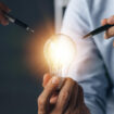 Businessman holds a glowing lamp Creative new idea Innovation brainstorming strategizing to make the business grow and be profitable Concept execution strategy planning and profit management