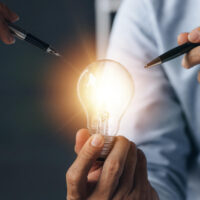Businessman holds a glowing lamp Creative new idea Innovation brainstorming strategizing to make the business grow and be profitable Concept execution strategy planning and profit management