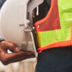 Engineer holding white helmet safety hard hat copy spec