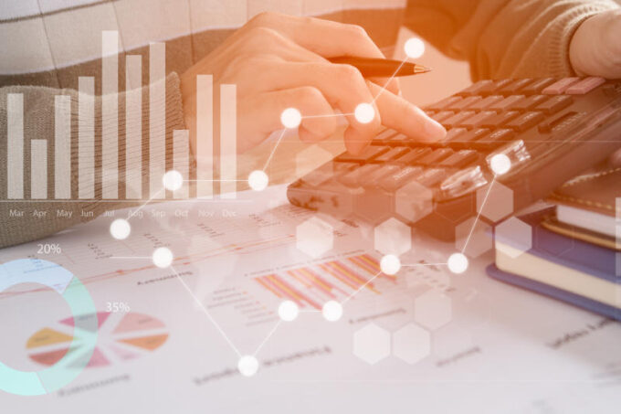 Young finance market analyst working at office at white tableBusinessman analyze document and the calculator in handsGraphs and diagram on notebook screen