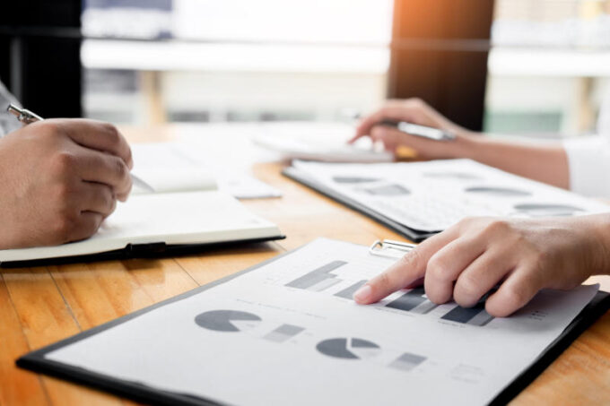 Business man analysed report of profit finance data graph document in his office