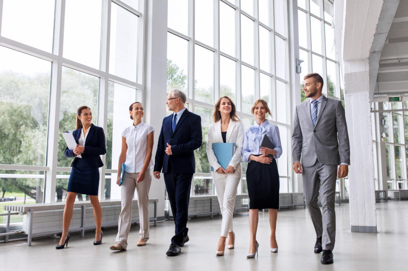 business people walking along office building