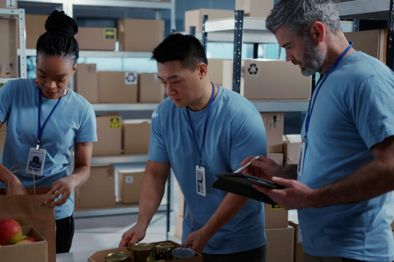 Charity Help Center Aid Organisation Multi-ethnic Young Volunteer Team Cooperating in Free Food Delivery Preparation Coworking at Warehouse