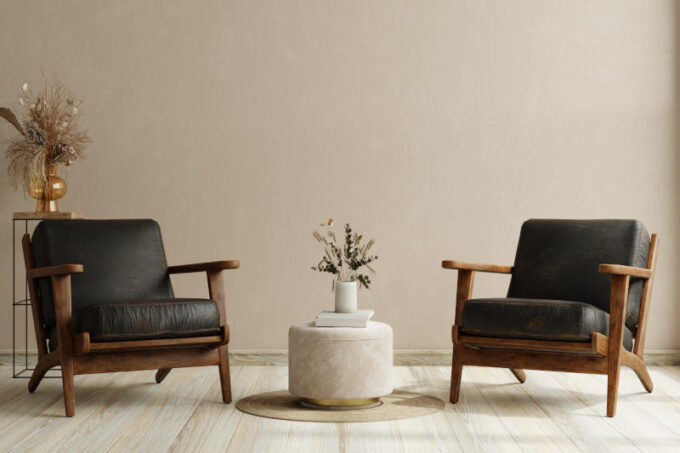 Living room with two leather armchair on empty cream color wall background