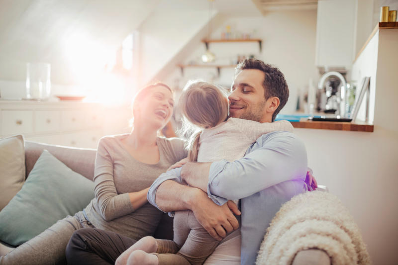 Happy young family relaxing on the couch at home