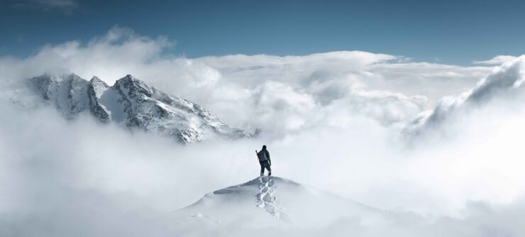 hiker on top of a snowy mountain - IMD Business School