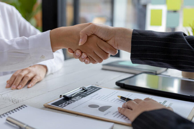 The job interviewer and the job applicant are holding hands afte