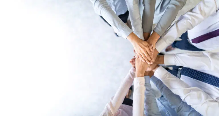 Stack of hands Unity and teamwork concept - IMD Business School