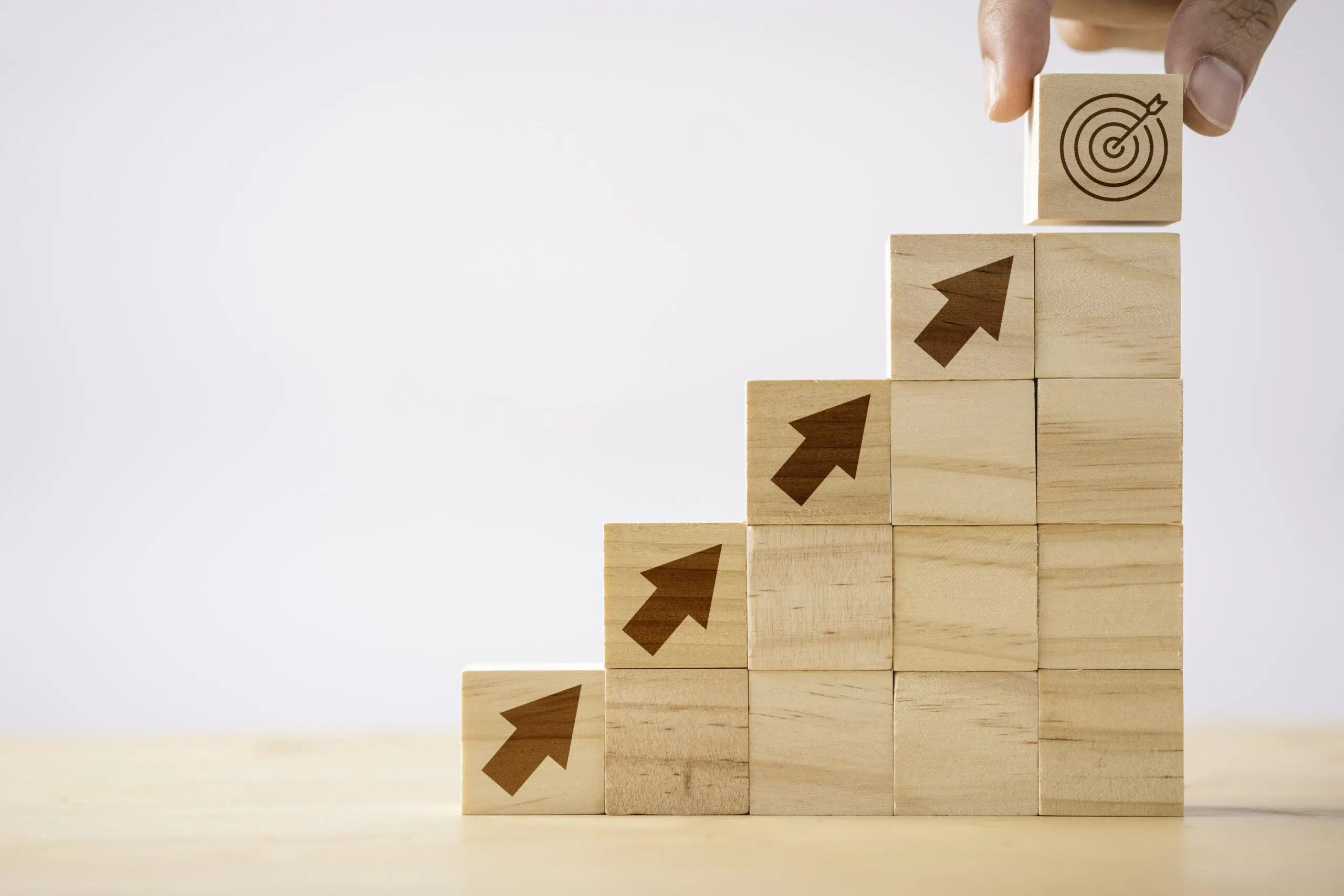 Hand putting print screen dart and target board wooden cube on up arrows Target of investment and business concept - IMD Business School