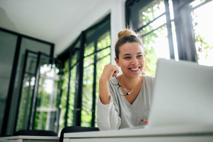 Beautiful smiling girl using laptop Close-up