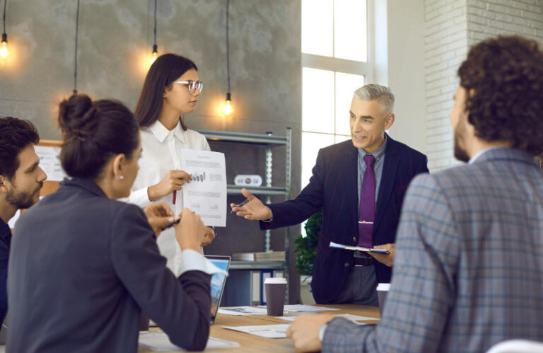 Senior manager presenting his report to a team of coworkers in a corporate meeting