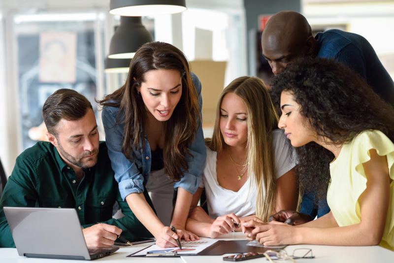 Multi-ethnic group of young men and women studying indoors