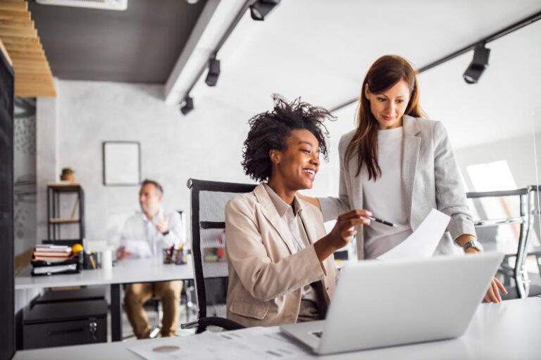 Woman showing another colleague a graph on a piece of paper