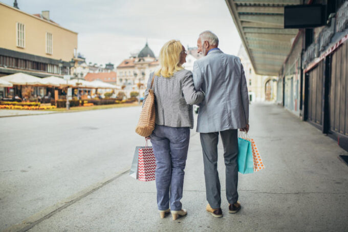 Senior couple carrying shopping bags and enjoying to shopping