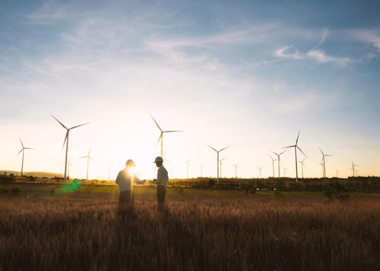 Investors and technicians are standing in talks about wind turbine power generation Wind turbine farm is an alternative electricity source Concept of sustainable resources Renewable energy concept