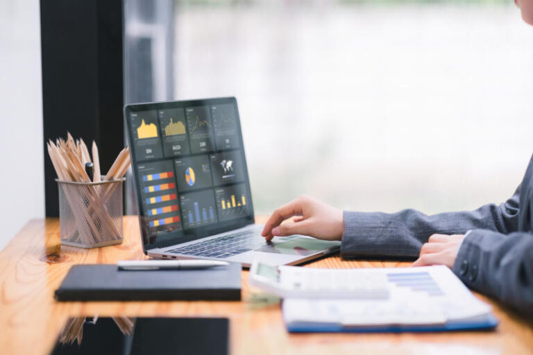 Businesswoman accountant using a calculator graphs and charts to analyze market data balance sheetsaccountsand net profits in order to plan new sales strategies